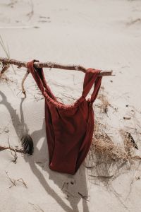 Kaboompics - Red One-Piece Swimsuit Hanging on Driftwood