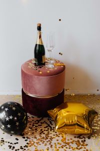 Kaboompics - Champagne Bottle And Flute On Pink Velvet Ottoman With Gold Confetti