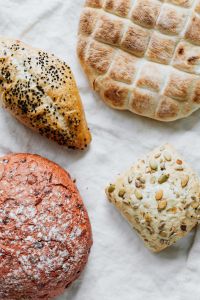 Kaboompics - Slovenian Bread Platter with Seeded Roll and Beetroot Loaf, Traditional Bakery Styling