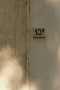 Kaboompics - House Number on Plaster Wall with Sunlight and Shadows, Italy