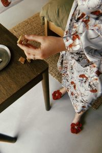 Kaboompics - Overhead Woman in Floral Dress at a Wooden Table with Red Flower Shoes