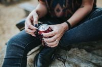Kaboompics - Hands Holding a Red Cola Can During a Beach Break