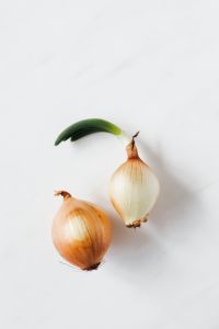 Kaboompics - Sprouted Yellow Onion with Curved Green Shoot for Minimal Food Styling