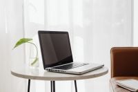Kaboompics - Laptop and Glass-Planted Green Leaf on White Table by a Leather Sofa, Home Office Lifestyle