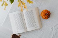 Kaboompics - Open Book Orange Pumpkin and Oak Leaves on White Linen