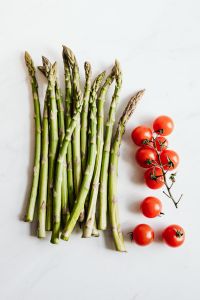 Kaboompics - Fresh Asparagus and Vine Tomatoes on White, Vertical Food Ingredient Flat Lay