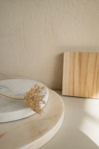 Kaboompics - Dried Flower on Round Stone Pedestal with Wood Block