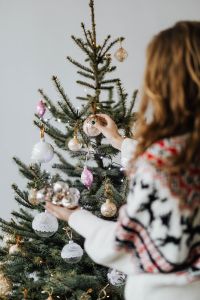 Kaboompics - Woman Decorating Christmas Tree with White and Pink Ornaments