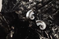 Kaboompics - Silver Spiral Earrings on a Black Textured Surface