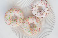 Kaboompics - Three White Iced Donuts with Colorful Sprinkles on a Glass Plate
