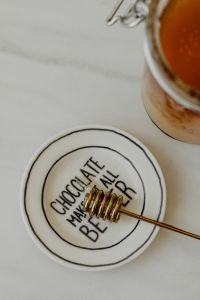 Kaboompics - Lettered Ceramic Plate with Honey Dipper and Jar, Minimal Food Styling with Copy Space