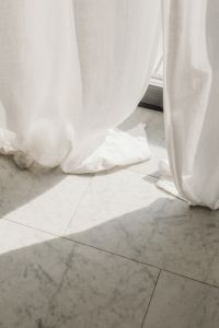 Kaboompics - White Curtains Over a Marble Tile Floor in Sunlight