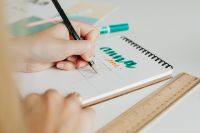 Kaboompics - Pencil Drafting a Logo Sketch beside Teal Lettering and Wooden Ruler