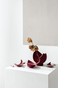 Kaboompics - Dried Rose in a Broken Burgundy Vase on a White Plinth
