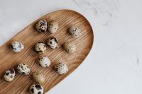 Kaboompics - Quail Eggs on an Oval Wooden Tray with Marble Copy Space for Easter Recipes