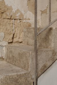 Kaboompics - Weathered Limestone Steps with Metal Railing and Peeling Plaster