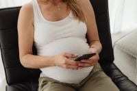 Kaboompics - Pregnant Woman Holding a Smartphone in a Chair