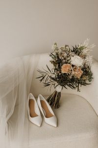 Kaboompics - White Wedding Heels and Bridal Bouquet on a Neutral Chair