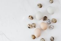 Kaboompics - Speckled Quail and Chicken Eggs on White Marble with Seasonal Easter Copy Space