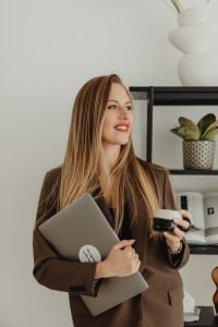 Kaboompics - Woman Holding Laptop and Coffee in Studio