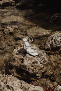 Kaboompics - Single White Ankle-Strap Heel on a Tide-Pool Rock
