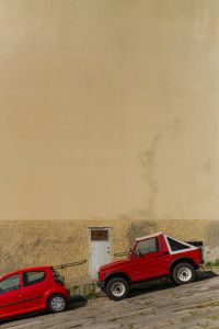 Kaboompics - Red Cars Parked Against a Weathered Italian Plaster Wall
