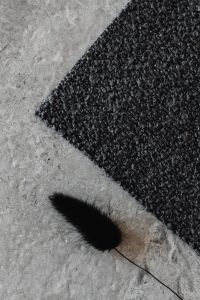 Kaboompics - Black Bouclé Upholstery Fabric Swatch on Gray Stone
