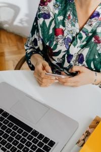 Kaboompics - Woman Using a Smartphone Beside a Laptop at a Home Desk