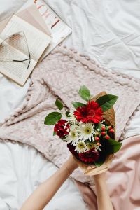 Kaboompics - Romantic Bedside Reading With Flowers and Pink Throw