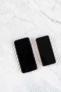 Smartphones and Laptop on White Marble with a 2020 Planner: Minimalist Tech Workspace Flat Lay