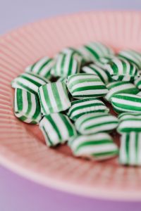 Kaboompics - Green and White Striped Candy on Pink Plate with Soft Pastel Copy Space
