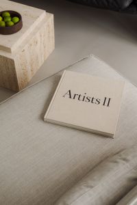 Kaboompics - Artists II Art Book on Beige Sofa Beside Travertine Table