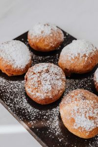 Kaboompics - Close-Up of Powdered Pączki on a Dark Serving Board