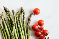 Kaboompics - Close-Up of Fresh Asparagus and Cherry Tomatoes on a White Background