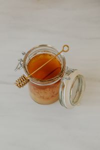 Kaboompics - Honey Jar with Dipper on a Pale Counter, Vertical Food Background with Copy Space