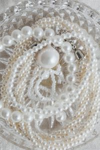 Kaboompics - Close-Up of White Pearl Necklaces and Pendants in a Clear Glass Bowl, Neutral Jewelry Flat Lay