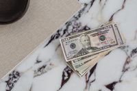 Kaboompics - Fifty Dollar Stack on Marble with Linen and Black Bowl