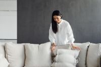 Kaboompics - Woman Styling a Linen Sofa with Cushions
