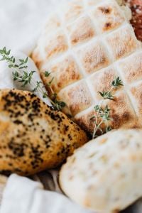 Kaboompics - Close-Up of Scored Slovenian Bread with Fresh Thyme, Rustic Bakery Food Photography