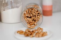 Kaboompics - Walnuts Pouring from a Tipped Glass Jar onto a Plate beside Flour Storage
