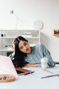 Kaboompics - Asian Woman Writing Notes with a Coffee Cup and Laptop