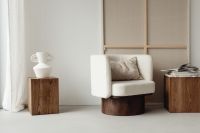 Kaboompics - White Upholstered Armchair with Wooden Side Tables and Ceramic Decor