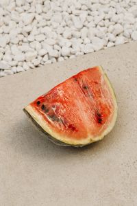 Kaboompics - Watermelon Slice Still Life on Beige Surface and White Pebbles
