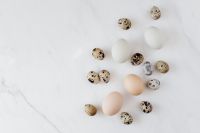 Kaboompics - Quail and Chicken Eggs Scattered on White Marble, Easter Flat Lay with Copy Space