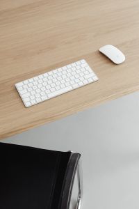 Kaboompics - Vertical Oak Desk Setup with White Keyboard, Mouse and Black Chair