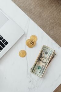 Kaboompics - Bitcoin Tokens and US Dollar Bill by Laptop