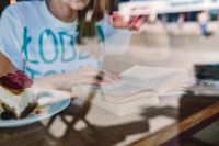 Kaboompics - Woman Reading a Book with Coffee and Cake at a Coffee Shop