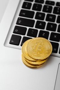 Kaboompics - Stacked Bitcoin Coins on Laptop Touchpad