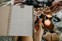 Kaboompics - Writing in a notebook lying in bed, with coffee, candles, and gingerbreads