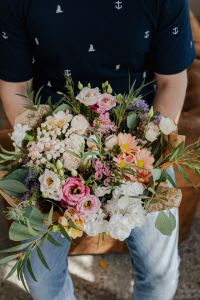 Kaboompics - Close-Up Mixed Floral Bouquet Held over Jeans, with Pink Roses and Peach Gerberas